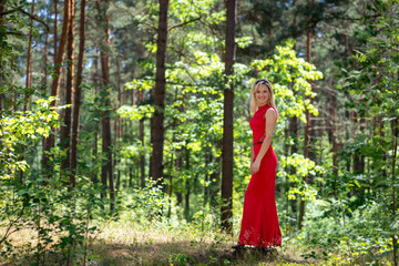 Beautiful, blonde woman portrait on a forest background. Copy space.