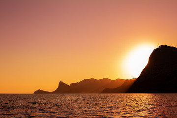 Naklejka na ściany i meble mountains in the sea at sunset