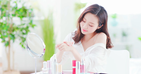 asian woman applying hand cream