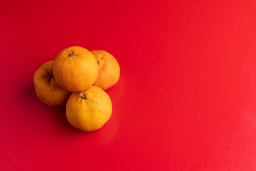 Orange fruits isolated on red background, Lunar Chinese New Year theme concept.
