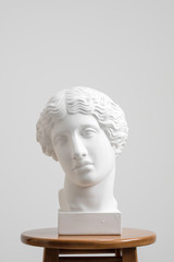Obraz premium Plaster head, antique sculpture for learning to draw. Standing on a stool on a white background.
