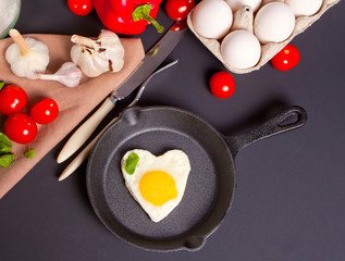 Heart shape scrambled eggs on iron dark pan