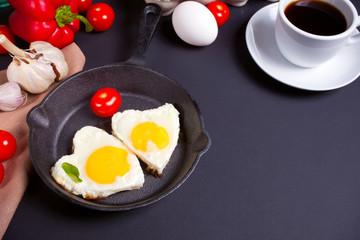 Heart shape scrambled eggs on iron dark pan