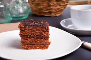 Delicious chocolate cake on the white plate on the black table
