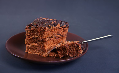 Delicious chocolate cake on the brown plate on the black table