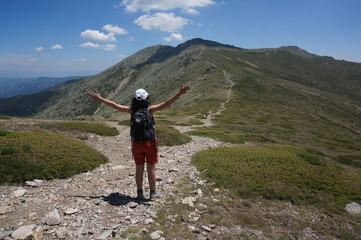 excursionista abre los brazos ante la montaña