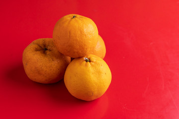 Orange fruits isolated on red background, Lunar Chinese New Year theme concept.