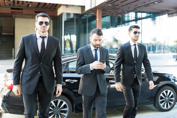 Private Security Bodyguards Walking By Businessman