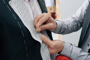 Close-up image of tailor making wedding suit for man