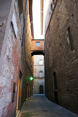 Dark medieval narrow street of Siena old town, Tuscany, Italy