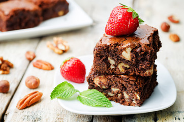 Fototapeta na wymiar chocolate nut brownie cake decorated with strawberries