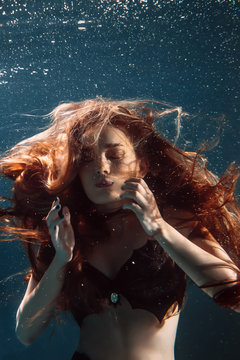 Underwater portrait freediver girl with red hair