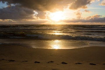 sunset in the cloudy sky over the stormy sea