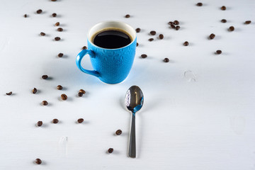 A cup of coffee on a light wooden background.