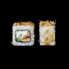 Sushi. Bonito roll with baked salmon in teriyaki sauce, cucumber, cream cheese and tuna chips, isolated in black background