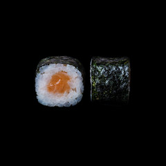 Sushi. Roll with salmon in nori leaf, isolated in black background