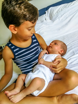 Elder brother holding his newborn brother in his arms