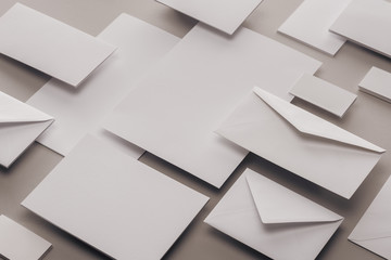 close up of empty white papers and envelopes on grey background