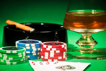 The concept of gambling, cards and chips with a glass of cognac and a cigar