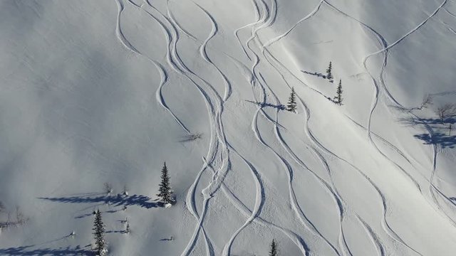 Aerial drone shot ski trail of snowy mountain slope