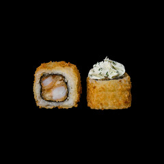 Sushi. Baked roll with tempura shrimp, cream cheese and herbs, isolated in black background