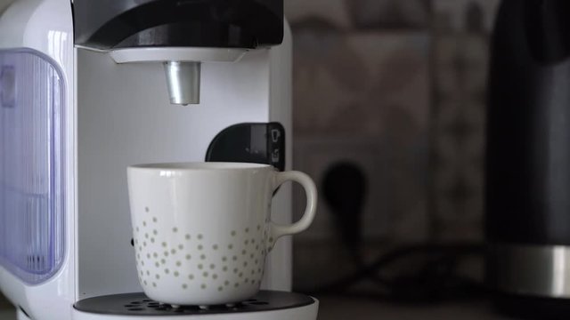 Home capsule coffee machine prepares a cup of fresh coffee