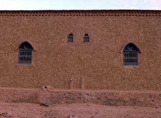 Fototapeta na wymiar Hauswand eines Marokkanischen Hauses. Die Wände sind aus Lehmziegel und werden mit einem Gemisch aus Lehm und Stroh verputzt.