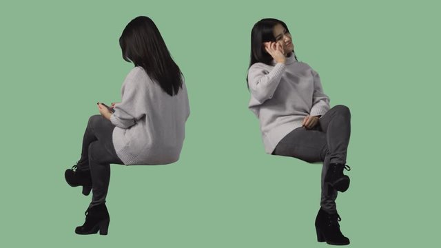 Brunette woman is sitting and talking by cellphone. Pre-keyed green screen video