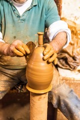 pottery, workshop, ceramics art concept - male master works with hands and potter wheel . 