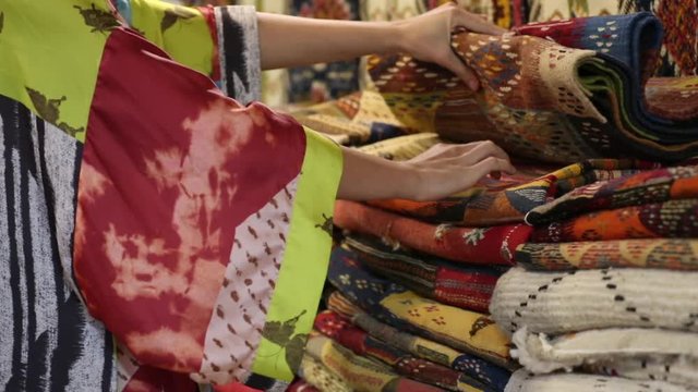 Women looking through different kinds of persian carpets on an Moroccan bazaar.