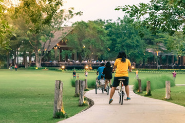 People exercising by cycling in the evening at the public park.