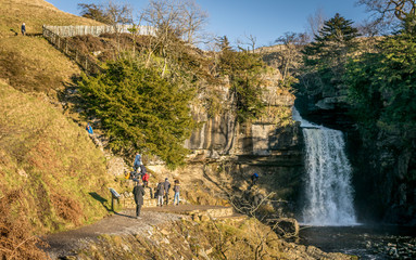 people enjoying the view of a waterfall in Yorkshire, England. 