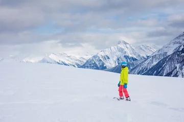 Fotobehang Girl snowboarder having fun in the winter ski resort. © Max Topchii