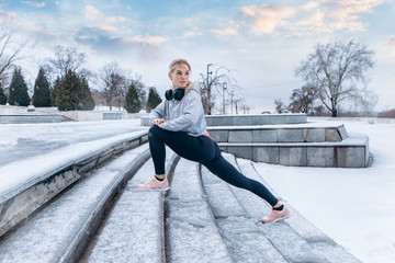 fitness girl climbs the stairs, sport, exercising, training on city street over snow