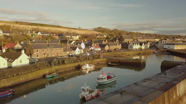 Aerial footage of Johnshaven harbour and town at sunrise, Aberdeenshire, Scotland