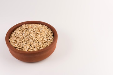 Dry rolled oatmeal in bowl isolated on white background.