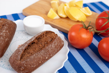 black buns, salt, lemon and tomatoes on a sprig