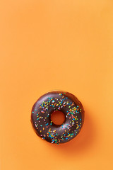 Single sweet donut with icing on a colorful background viewed from above. Top view. Copy space.