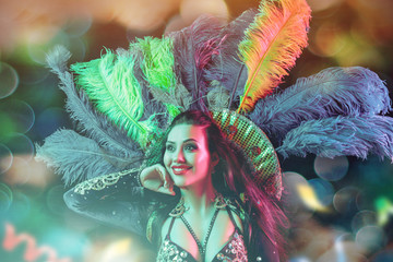 Beautiful young woman in carnival peacock costume. Beauty model woman at party over holiday...