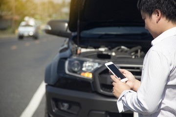 Using a mobile phone call a car mechanic because car was broken.
