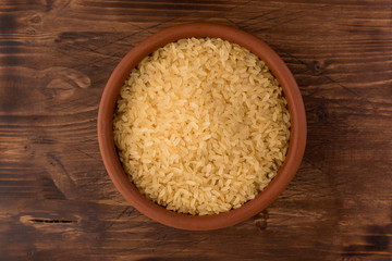 white rice in bowl on wooden table background
