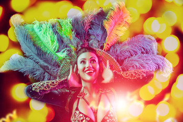 Beautiful young woman in carnival peacock costume. Beauty model woman at party over holiday...