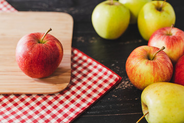 group of apples on wooden cutting board with napkin