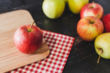 group of apples on wooden cutting board with napkin