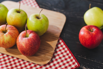 group of apples on wooden cutting board with napkin