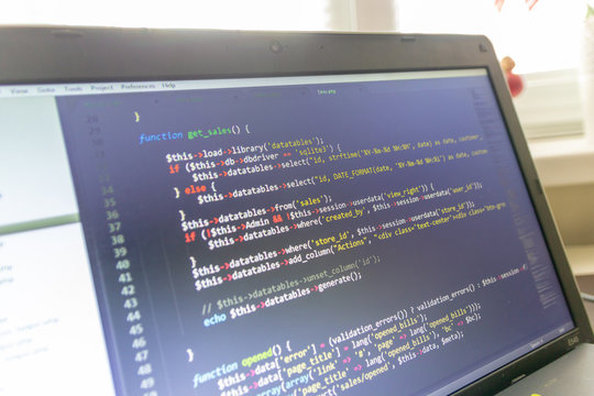 Modern software development background: nice looking laptop with programm on display.