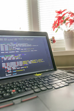 Modern software development background: nice looking laptop with programm on display.