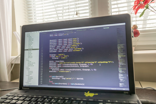 Modern software development background: nice looking laptop with programm on display.