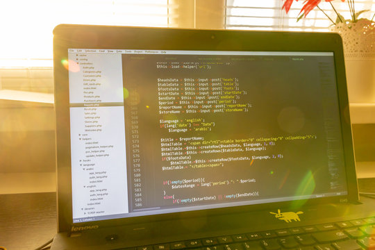 Modern software development background: nice looking laptop with programm on display.