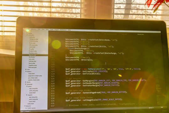 Modern software development background: nice looking laptop with programm on display.